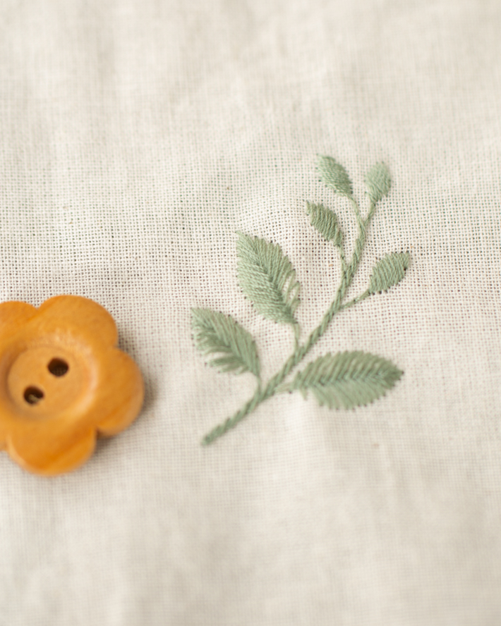 葉っぱの刺繍と生成り色の生地の表情